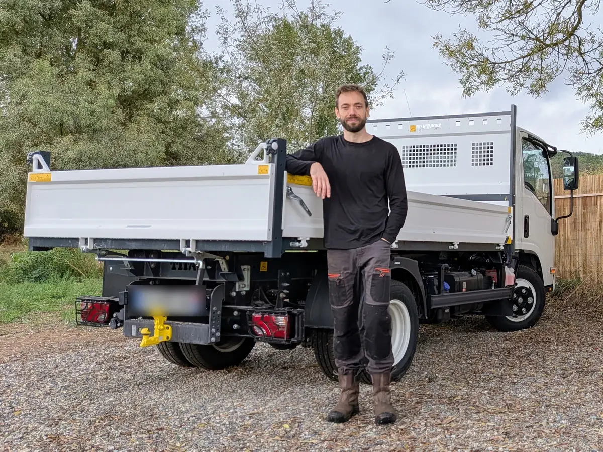 Julien, gérant d'Assainissement Julien, devant son camion benne
